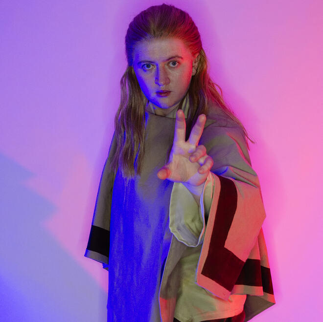 Brie, dressed as Jimmy Olsen from Superman (2025), looking into a camera.